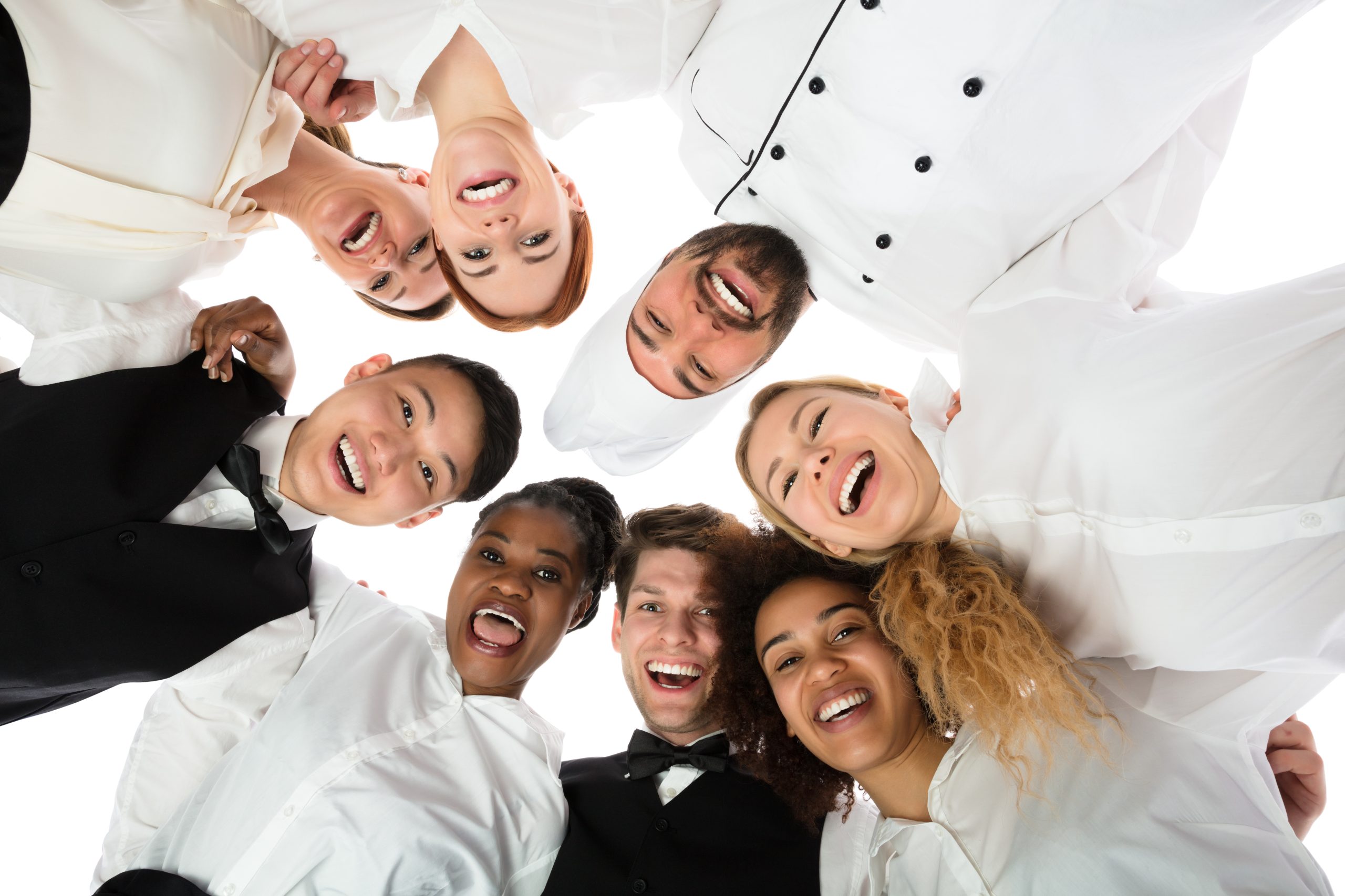 Low Angle View Of Happy Restaurant Staff Standing Against White Background